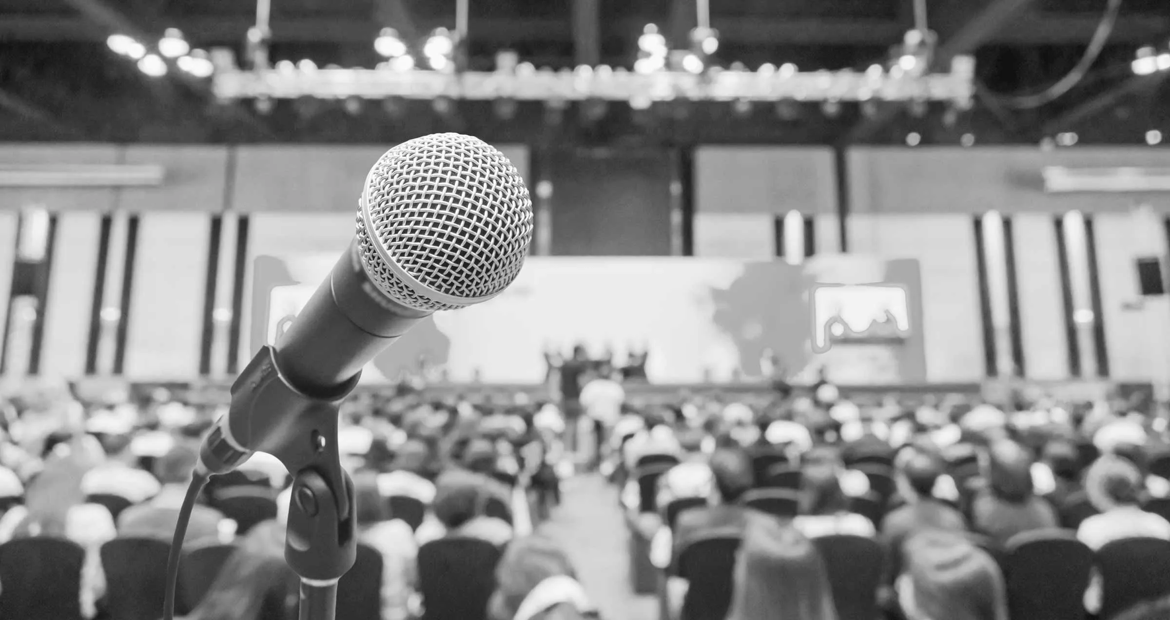 Mikrofon vor unscharfem Konferenzpublikum